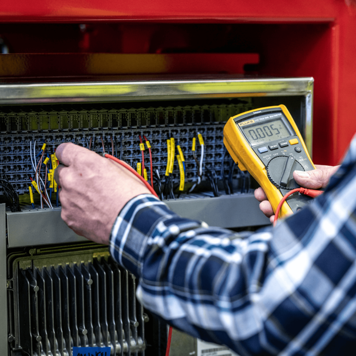 Man with checkered shirt works with yellow test equipment