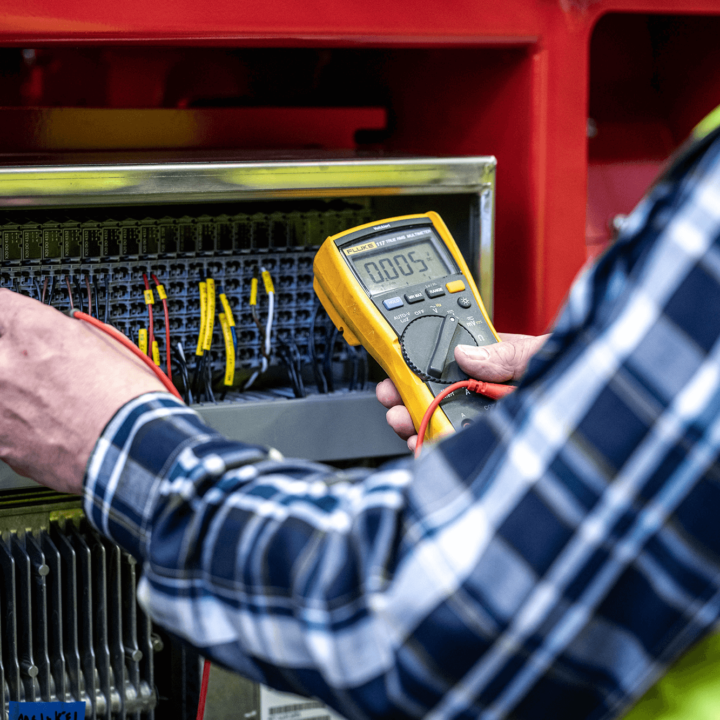 Man with checkered shirt works with yellow test equipment